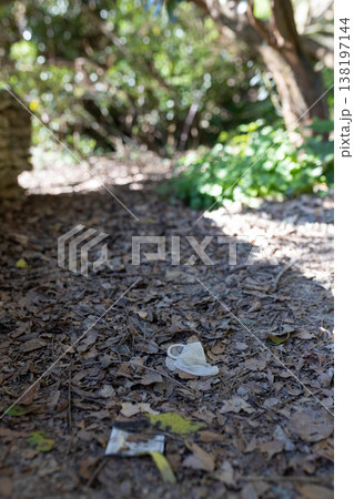Discarded face mask littering natural park environment Discarded face mask littering natural park environment 138197144
