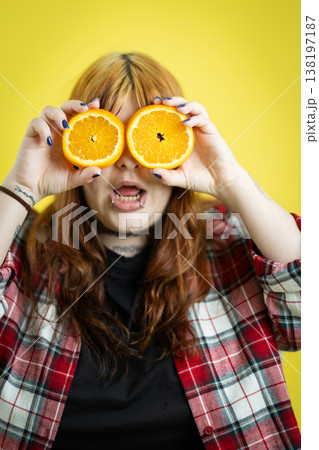 Young person holding orange halves creating funny eyes Young person holding orange halves creating funny eyes 138197187