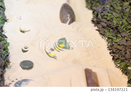War debris including unexploded ordnance and landmines in sand 138197221
