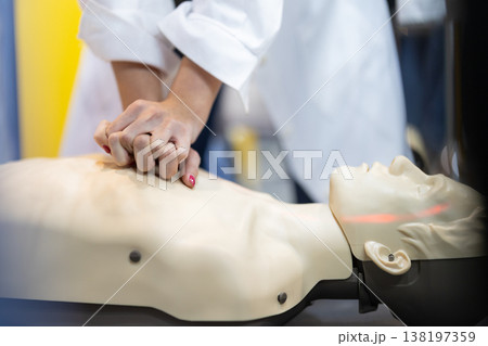 Hands pressing chest on cpr mannequin during first aid training Hands pressing chest on cpr mannequin during first aid training 138197359