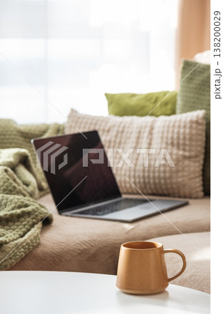 Laptop on Sofa and Coffee Mug on Table. Laptop on Sofa and Coffee Mug on Table. 138200029