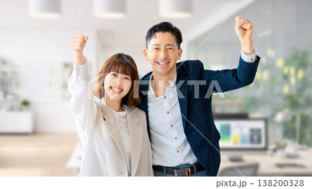 ガッツポーズをする笑顔のビジネスマン男女 ガッツポーズをする笑顔のビジネスマン男女 138200328
