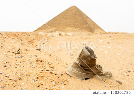 Red pyramid located in Dahshur, Egypt. The pyramid is surrounded by sandy terrain and rocky formations, showcasing ancient Egyptian architecture. 138201780