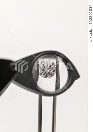 Single diamond examined under a magnifying tool Single diamond examined under a magnifying tool 138202054