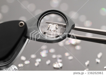 Close-up of jeweler examining diamond with loupe Close-up of jeweler examining diamond with loupe 138202061