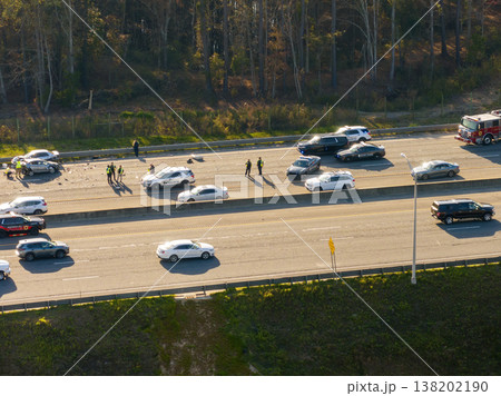 First responders responding to car accident site on American highway. Emergency services helping victims of vehicle crash on high speed road in USA. 138202190