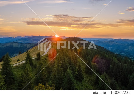 Colorful sunset in wild mountains. Dark pine forest illuminated with bright setting sun. Beautiful nature landscape Colorful sunset in wild mountains. Dark pine forest illuminated with bright setting sun. Beautiful nature landscape 138202283