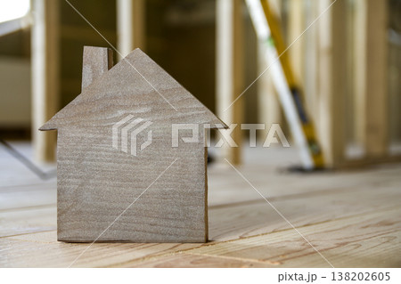 Close-up of simple small brown model house on blurred building tools background. Construction, building and investments in real estate, property and ownership of dream home concept. Close-up of simple small brown model house on blurred building tools background. Construction, building and investments in real estate, property and ownership of dream home concept. 138202605