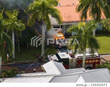 Car on fire in Florida after hurricane flooding caused electrical short circuit. Firefighters extinguishing burning vehicle Car on fire in Florida after hurricane flooding caused electrical short circuit. Firefighters extinguishing burning vehicle 138202671