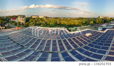 Blue photovoltaic solar panels mounted on building roof for producing clean ecological electricity at sunset. Production of renewable energy concept Blue photovoltaic solar panels mounted on building roof for producing clean ecological electricity at sunset. Production of renewable energy concept 138202703