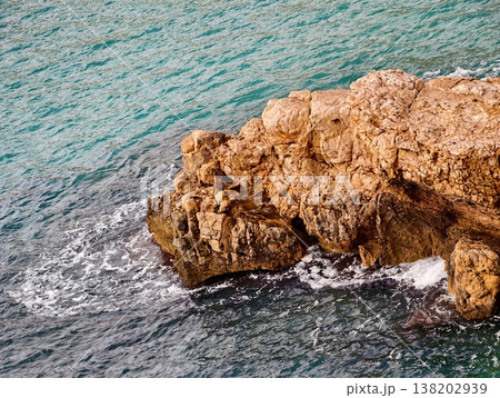 Colorful ocean and rocky coast, Serene turquoise waves crash against rugged coast for summer scenes Colorful ocean and rocky coast, Serene turquoise waves crash against rugged coast for summer scenes 138202939
