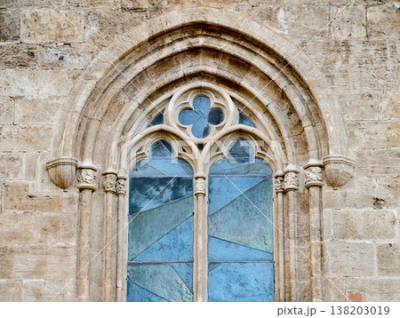 Gothic facade exhibits detailed tracery with patinated stone and vibrant stained glass panes Gothic facade exhibits detailed tracery with patinated stone and vibrant stained glass panes 138203019
