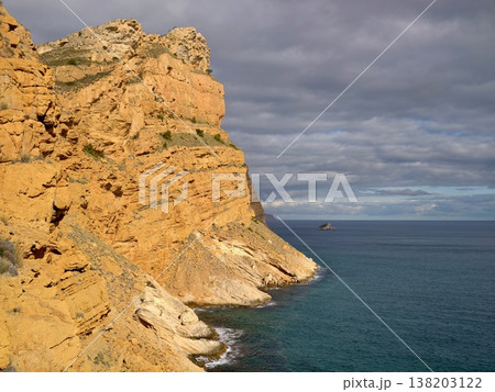 Distant island with cloudy sky, Imposing cliffside gaze over isolated islet beneath brooding skies Distant island with cloudy sky, Imposing cliffside gaze over isolated islet beneath brooding skies 138203122