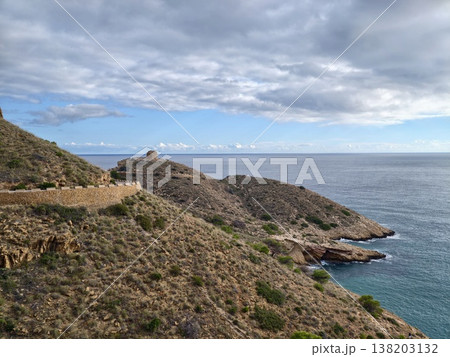 Coastal rock formation scene, Remote rocky headland with textured slopes and tranquil seawater Coastal rock formation scene, Remote rocky headland with textured slopes and tranquil seawater 138203132