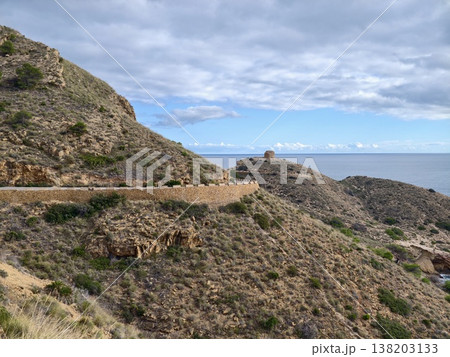 Majestic coastal scenery showcasing serpentine routes alongside shimmering sea and dynamic cloud formations 138203133