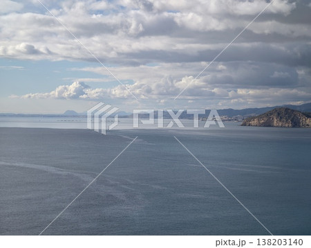 Wide open ocean beneath cloudy sky emphasizing calming waves and pristine shoreline preservation Wide open ocean beneath cloudy sky emphasizing calming waves and pristine shoreline preservation 138203140