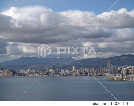 Dynamic weather highlights metropolitan seaside with towering buildings and mountain vistas in background Dynamic weather highlights metropolitan seaside with towering buildings and mountain vistas in background 138203144