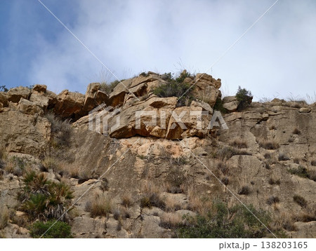 Majestic limestone formation stretching skyward with exposed layers and limited plant life 138203165