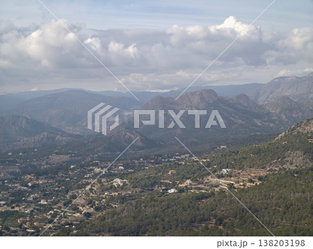 Expansive mountain range under soft blue sky featuring scattered clouds and tranquil atmosphere for branding Expansive mountain range under soft blue sky featuring scattered clouds and tranquil atmosphere for branding 138203198