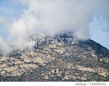 Highland shielded by fog, Alpine peak concealed beneath swirling clouds and atmospheric haze Highland shielded by fog, Alpine peak concealed beneath swirling clouds and atmospheric haze 138203232