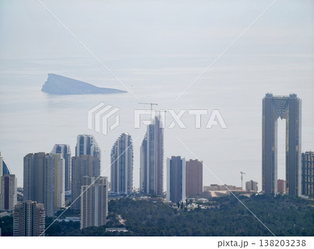 Mysterious aerial form hovers above bustling metropolis as skyscrapers and ships bustle below 138203238