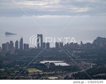 Cityscape mirrors water, Dusk silhouettes dance on still lagoon as cloudy sky looms with towering shapes Cityscape mirrors water, Dusk silhouettes dance on still lagoon as cloudy sky looms with towering shapes 138203245