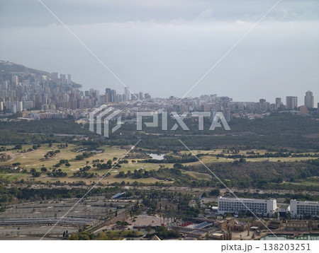 Blurry skyline features mixed buildings and lush greenbelt under diffuse weather conditions 138203251