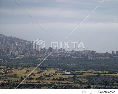Distant coastal urban environment featuring lush landscapes and layered skyline background 138203252