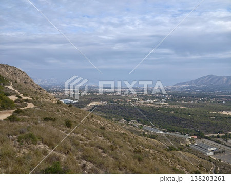 Charming hiking path through rocky terrain offering breathtaking views of nature and nearby urban backdrop Charming hiking path through rocky terrain offering breathtaking views of nature and nearby urban backdrop 138203261