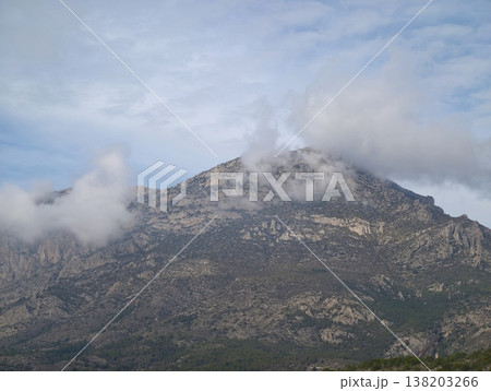 Cloudy rocky peak, Misty mountain with rugged rocks, Weathered granite slopes layered with clouds and mist Cloudy rocky peak, Misty mountain with rugged rocks, Weathered granite slopes layered with clouds and mist 138203266