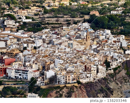 Exploring lively hillside town with sunlit buildings and narrow winding streets behind bell tower Exploring lively hillside town with sunlit buildings and narrow winding streets behind bell tower 138203346
