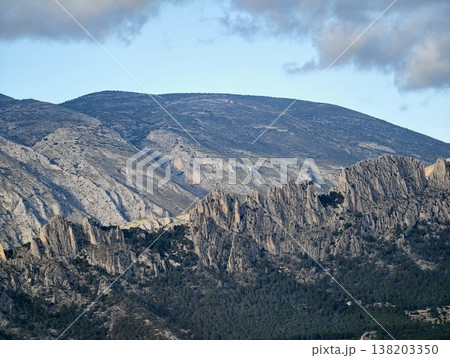 Steep cliff landscape, Dramatic cliff with layered rocks and clouds ideal for geological exploration and study 138203350