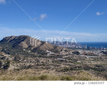 Hiking spot with stunning scenery, Sunlit meadow and winding trail amidst mountain and sea scenery Hiking spot with stunning scenery, Sunlit meadow and winding trail amidst mountain and sea scenery 138203357