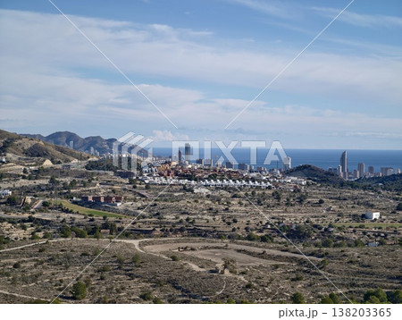 Cliffside village overlooking ocean, Hillside town with rooftops and distant ocean backdrop 138203365