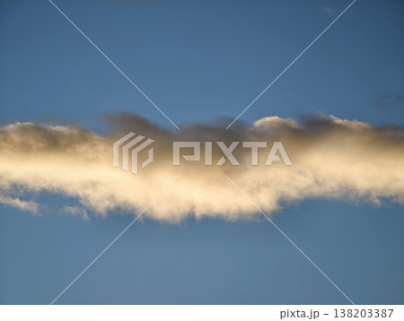 Sunlit textured clouds adorn peaceful sky, Calm horizon with radiant clouds stretches across azure expanse 138203387