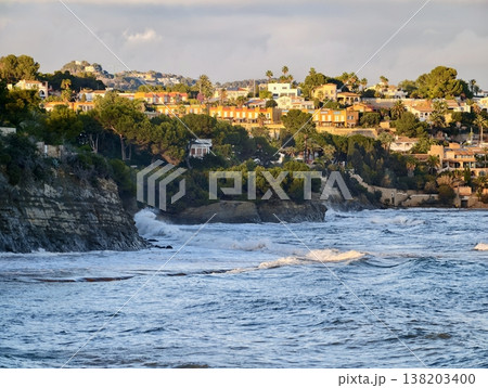 Rugged coast with crashing waves, Powerful ocean waves surge against steep rocky shoreline vibrantly 138203400