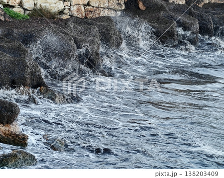 Coastal erosion scene, Weathered cliffs with crashing waves, Seaside rocky wall battered by surf and spray Coastal erosion scene, Weathered cliffs with crashing waves, Seaside rocky wall battered by surf and spray 138203409