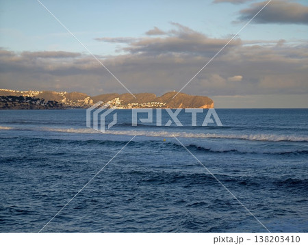 Calm ocean with distant shoreline, Expansive blue waters under tranquil dusk sky with distant headlands 138203410