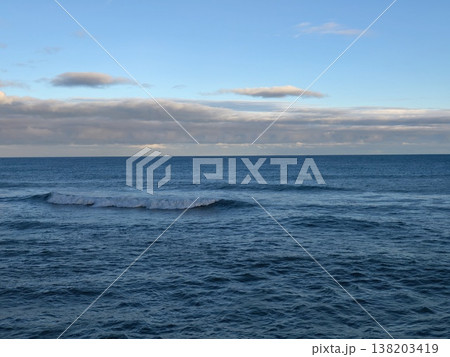 Gentle water under pastel sky, Peaceful coastal landscape with gentle waves and warm evening light 138203419