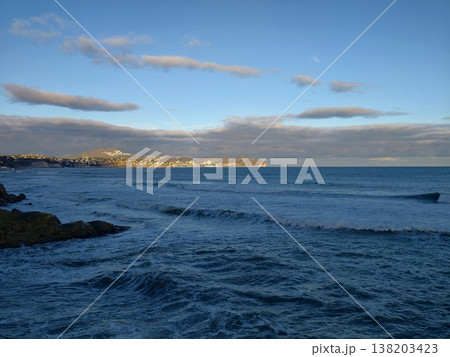 Coastline with town, Rocky shoreline meets quiet bay, Distant settlement along rugged coastal edge Coastline with town, Rocky shoreline meets quiet bay, Distant settlement along rugged coastal edge 138203423