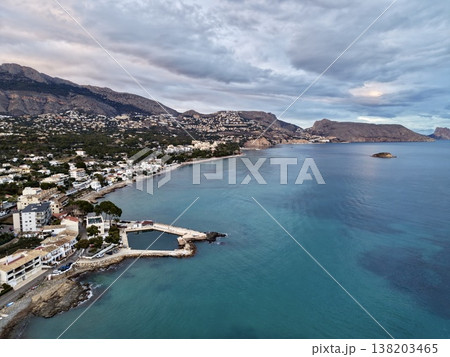 Serene seaside view, Tranquil beach scene featuring distant islet and expansive cloudy sky overhead Serene seaside view, Tranquil beach scene featuring distant islet and expansive cloudy sky overhead 138203465