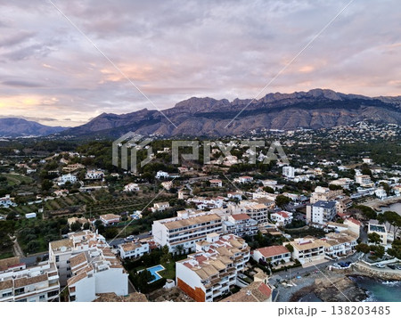 Aerial view of shoreline at dusk, Sunset over marina highlighting pier structures and coastline features 138203485