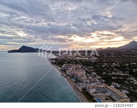 Seaside evening with glowing sky, Serene sunset illuminating shoreline with hotels and palm trees 138203497