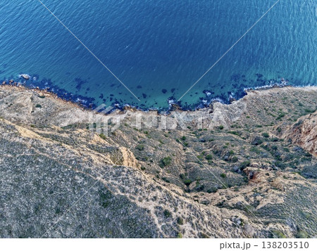 Drone captures shoreline with water, Aerial perspective showcases rocky shoreline and vibrant water scene Drone captures shoreline with water, Aerial perspective showcases rocky shoreline and vibrant water scene 138203510