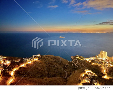 Illuminated path over ocean, Tranquil shoreline view with illuminated walkway and distant island Illuminated path over ocean, Tranquil shoreline view with illuminated walkway and distant island 138203527