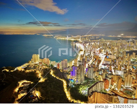 Vibrant seaside cityscape, Sunset glow illuminates bustling shoreline with vibrant city life Vibrant seaside cityscape, Sunset glow illuminates bustling shoreline with vibrant city life 138203529