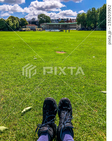 Individual with bare feet is standing on vibrant green grass, enjoying the warmth of sunlight, while wearing comfortable denim jeans, evoking a sense of relaxation and nature Individual with bare feet is standing on vibrant green grass, enjoying the warmth of sunlight, while wearing comfortable denim jeans, evoking a sense of relaxation and nature 138203902