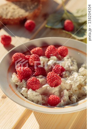 Ricotta or cottage cheese with fresh raspberries. 138204304