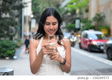 Young Asian Woman Using Smartphone on Hong Kong Street 138204571
