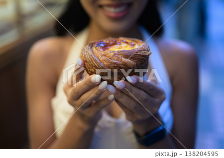 Young Asian Woman Holding Fresh Egg Tart in Hong Kong Young Asian Woman Holding Fresh Egg Tart in Hong Kong 138204595